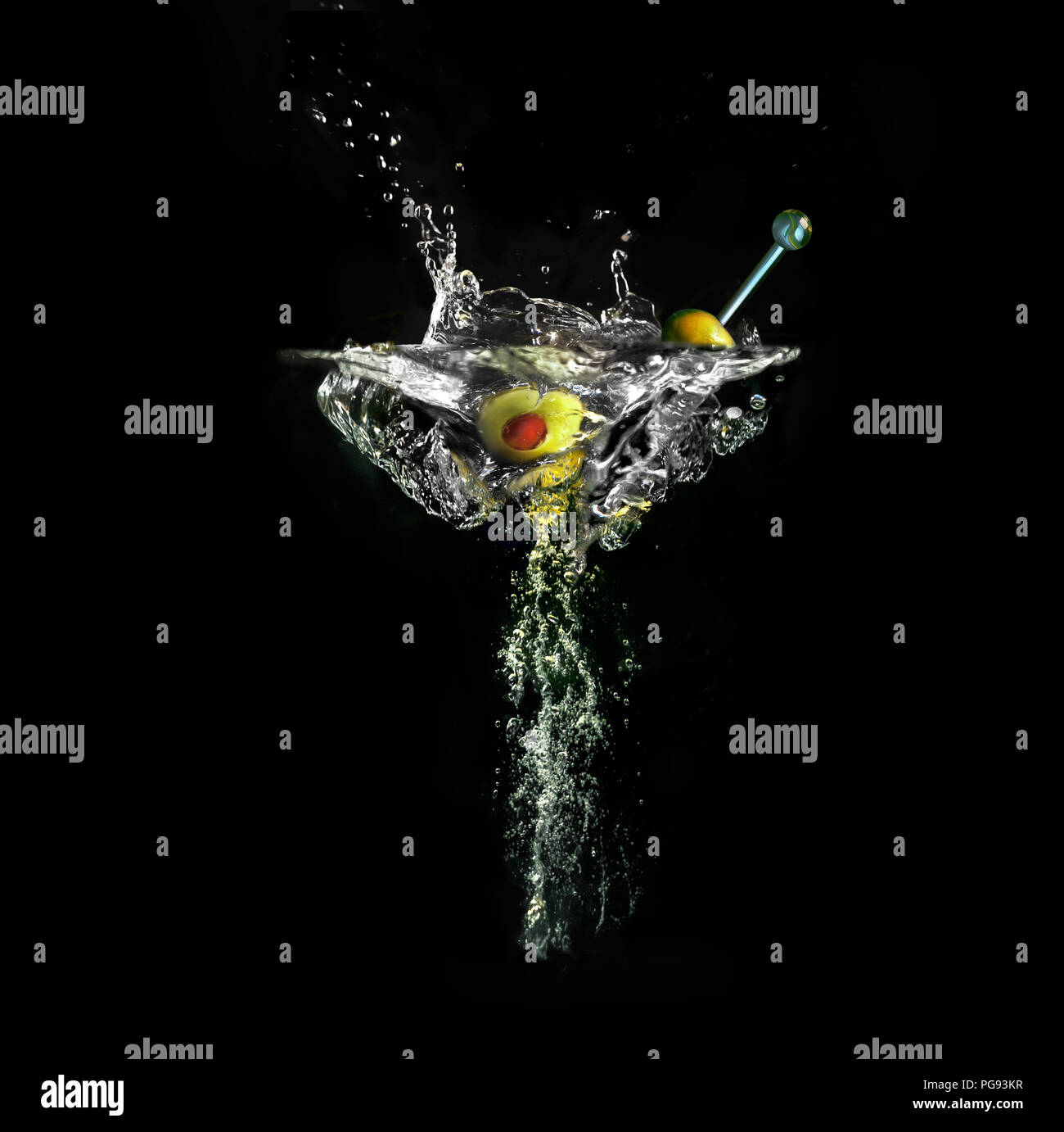 Martini with olives in imaginary wineglass out of water splashes and air bubbles on black background Stock Photo