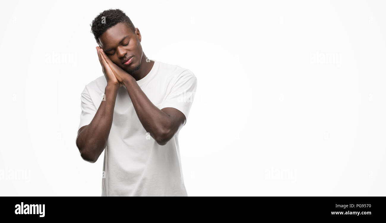 Young african american man wearing white t-shirt sleeping tired ...