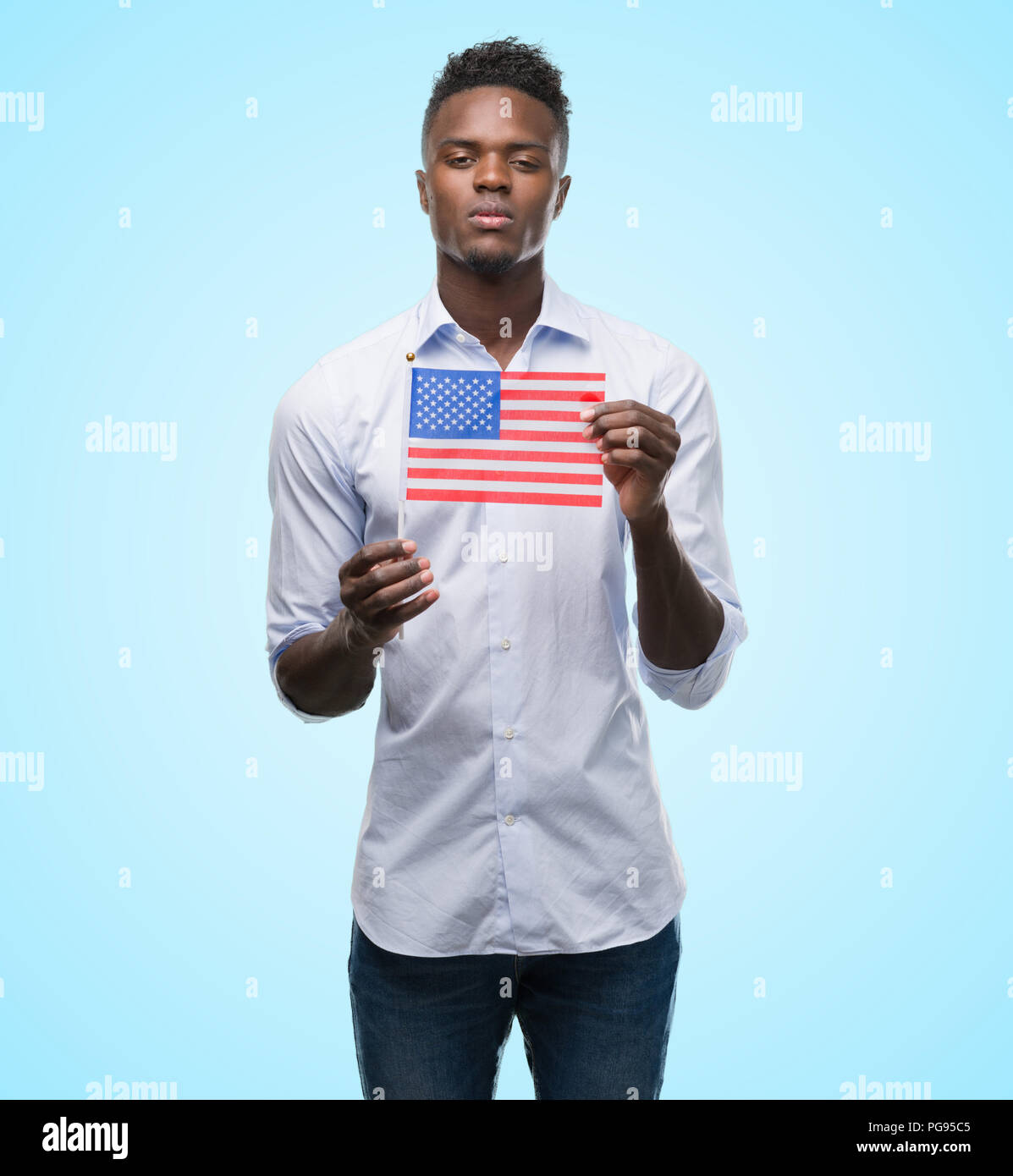 Young african american man holding USA flag with a confident expression ...