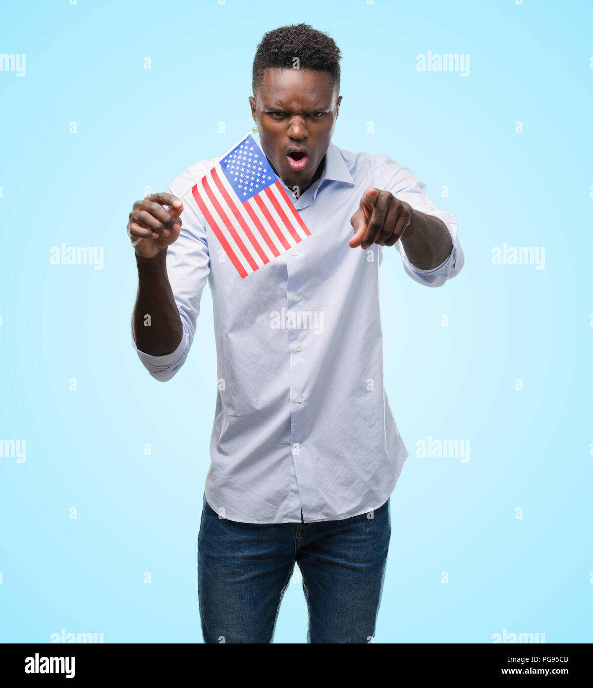 Young african american man holding USA flag pointing with finger to the ...