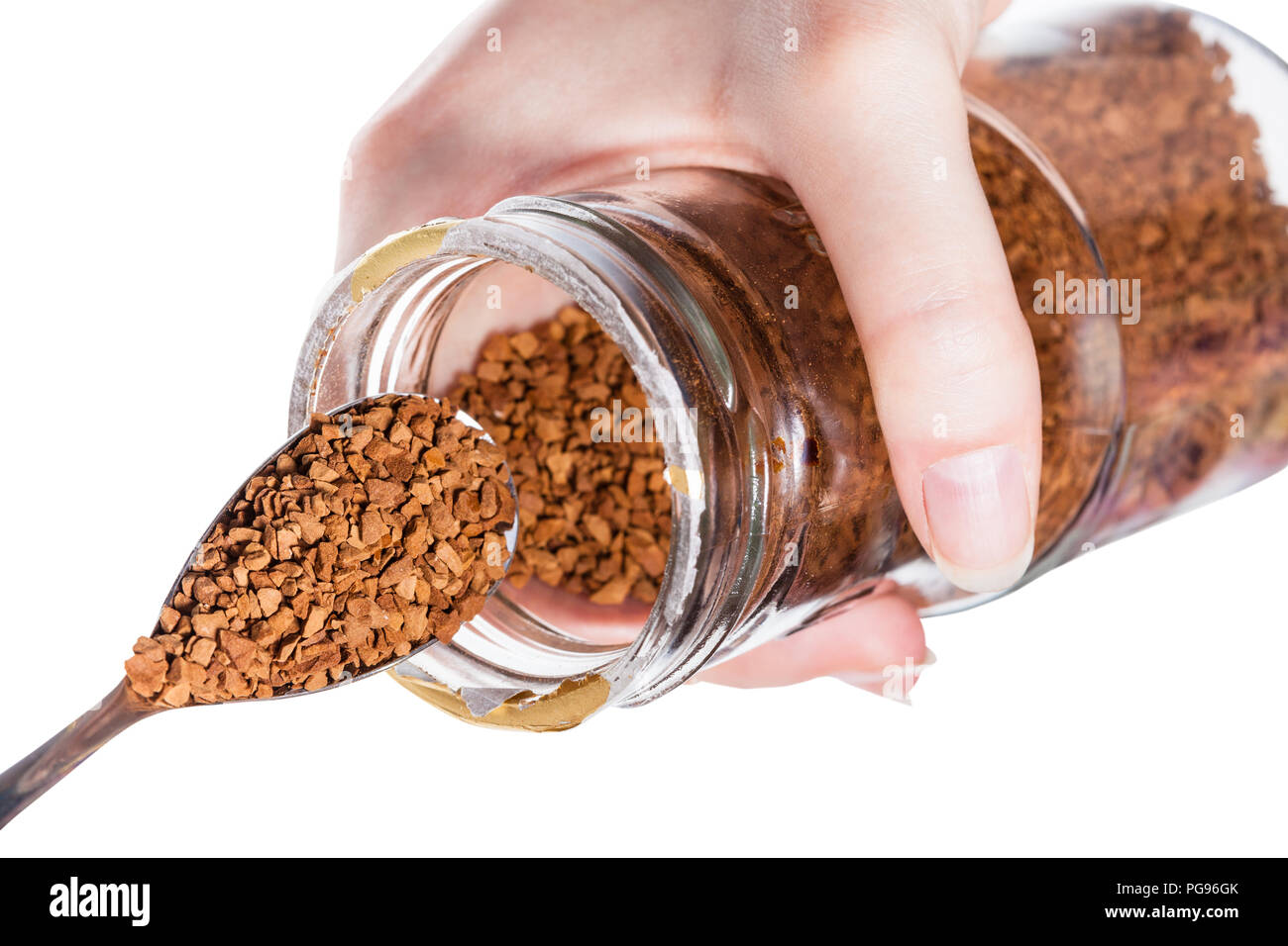 spoon scoops up soluble coffee from glass jar isolated on white