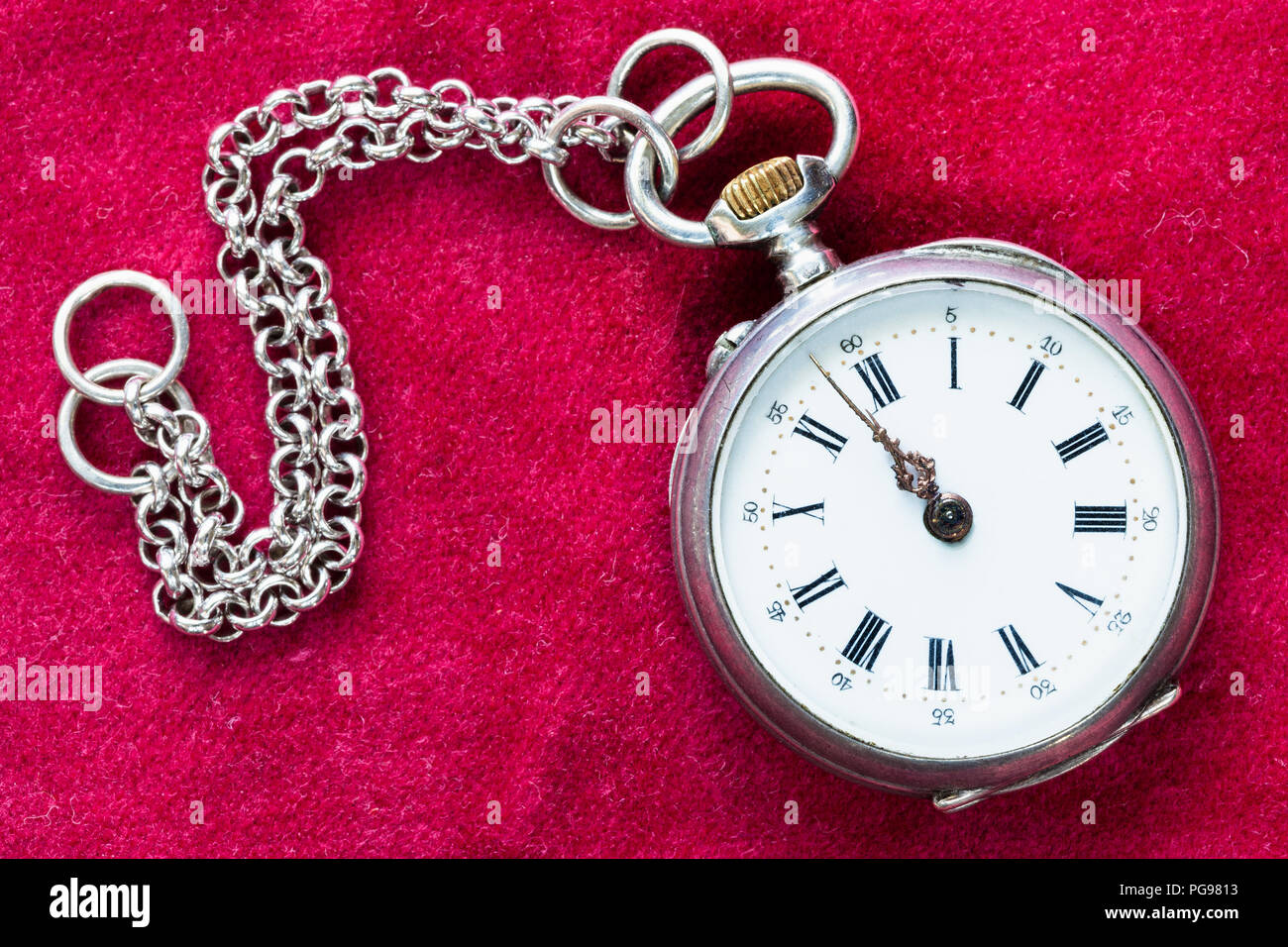 retro silver pocket watch with chain on red velvet background Stock