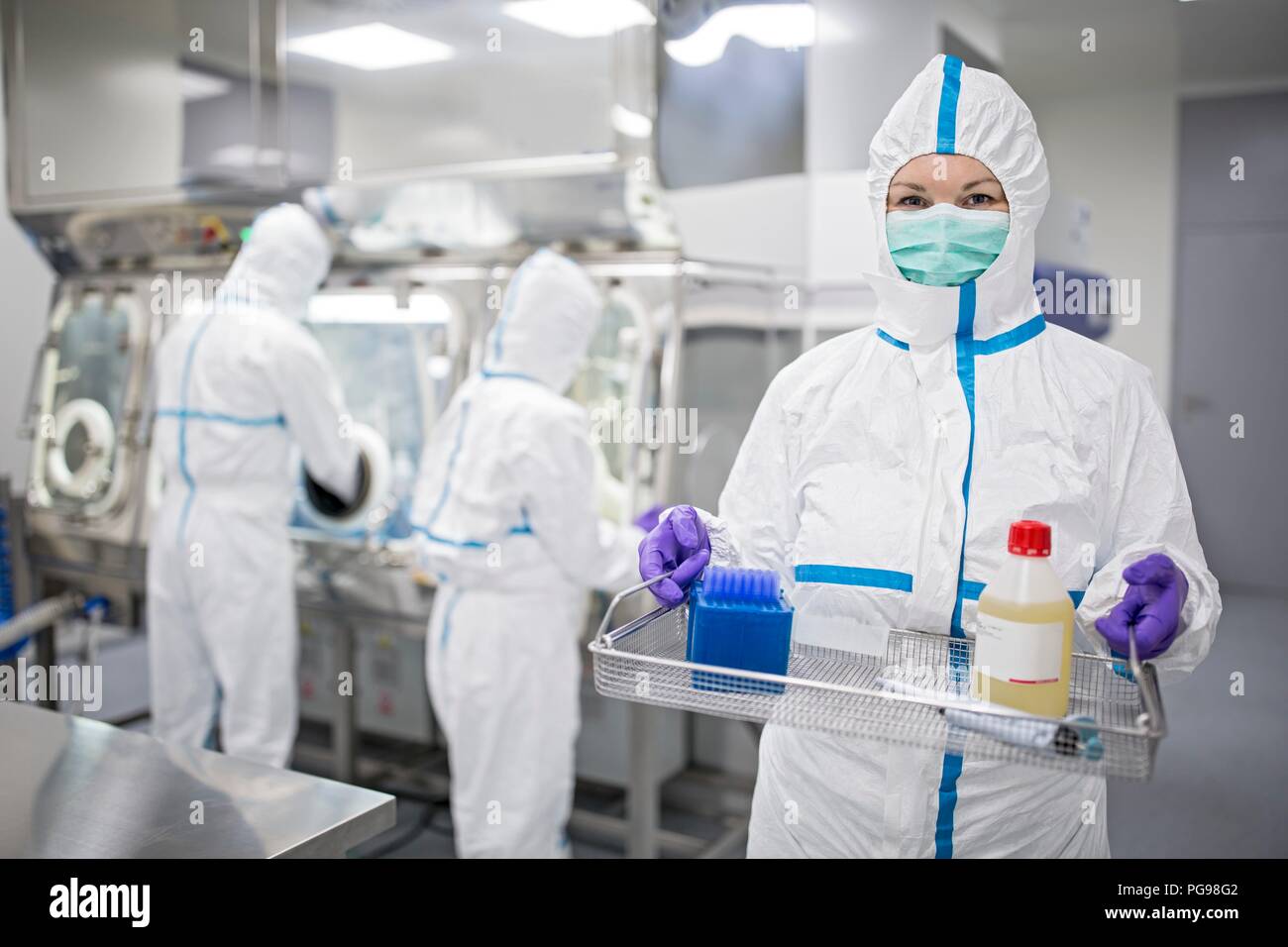 Technician carrying equipment in a laboratory that manufactures human tissues for implant. In the bottle is physiological solution, which helps to maintain cells in vitro. Tissues manufactured at the facility include bone and skin grafts. Stock Photo
