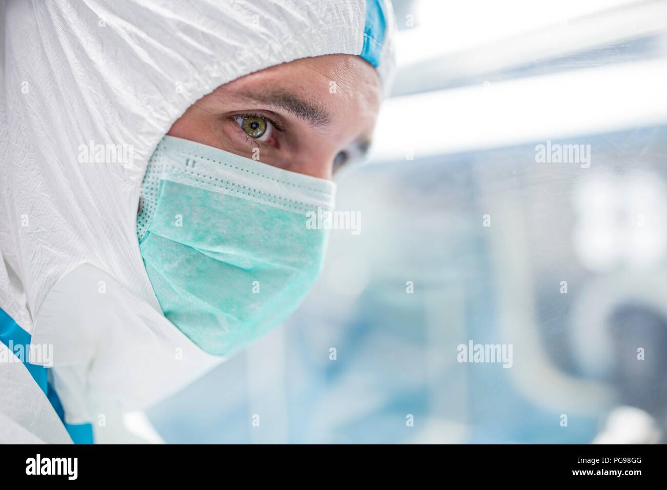 Closeup of a lab technician wearing a protective suit and face mask in