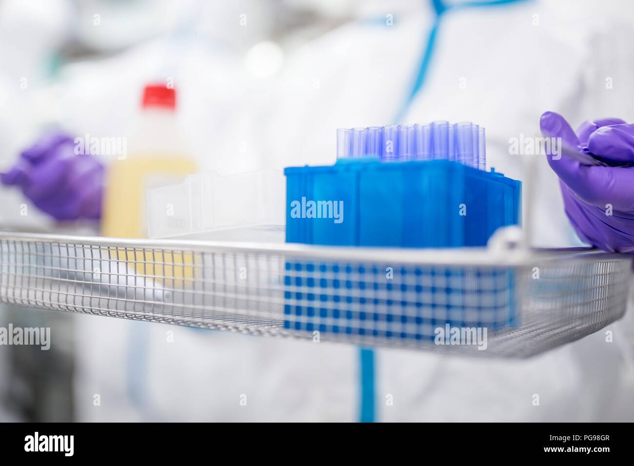 Technician carrying equipment in a laboratory that manufactures human tissues for implant. Such tissues include bone and skin grafts. Stock Photo