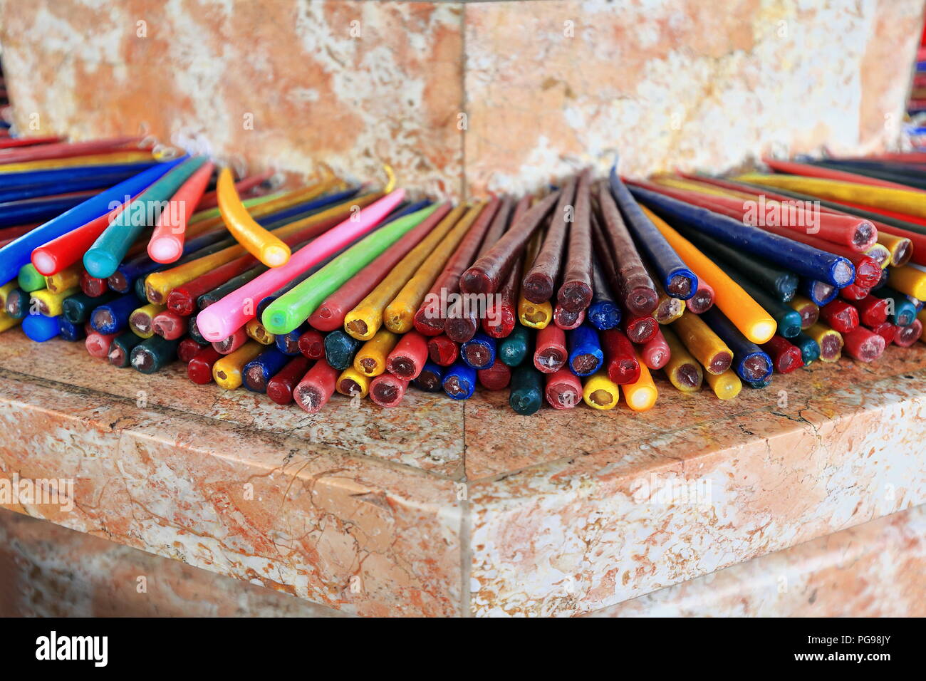 Many colored candles arranged for sale at the foot of the Magellan's Cross-Cruz de Magallanes housed in a chapel next to the Basilica del Santo Niño f Stock Photo