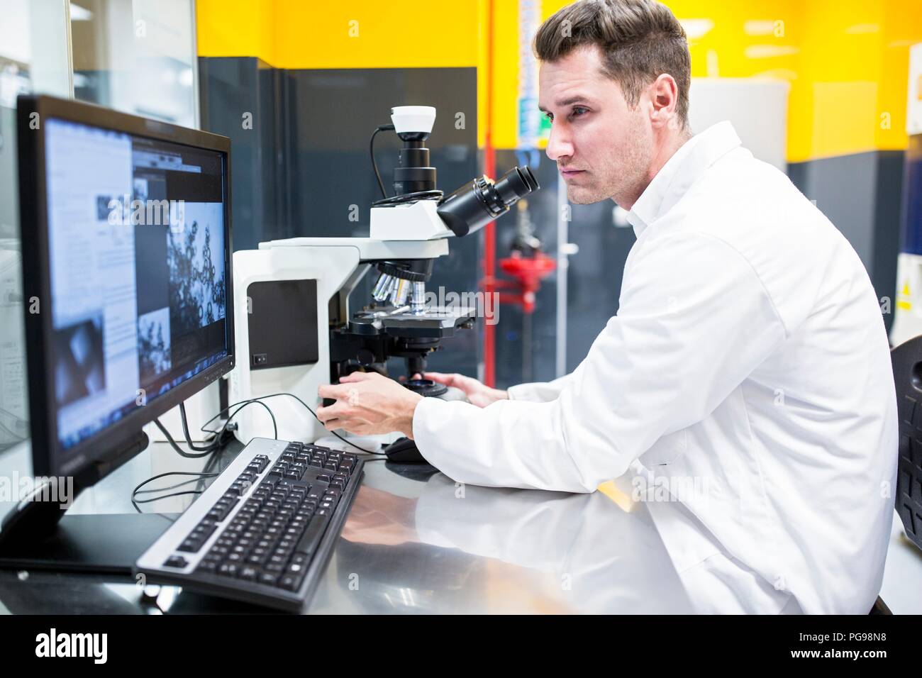 Scientist checking a nanofibre structure under a light microscope. Stock Photo