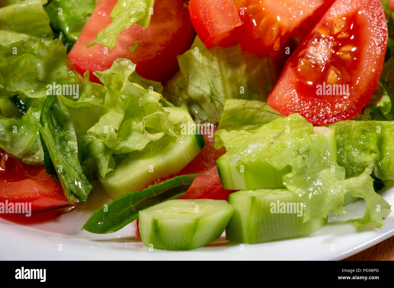 Closeup ingredients for vegetable dishes from tomato, cucumber and lettuce with shallow depth of focus with blur. Stock Photo