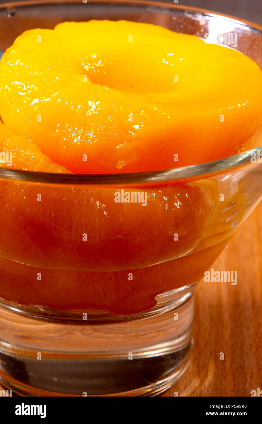 Glass with sweet canned peaches close-up with blur Stock Photo
