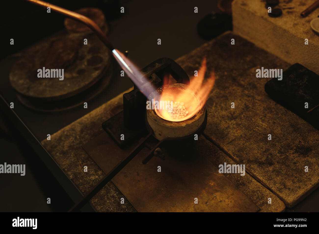 Melting gold in a small crucible for making jewelry. Goldsmith using