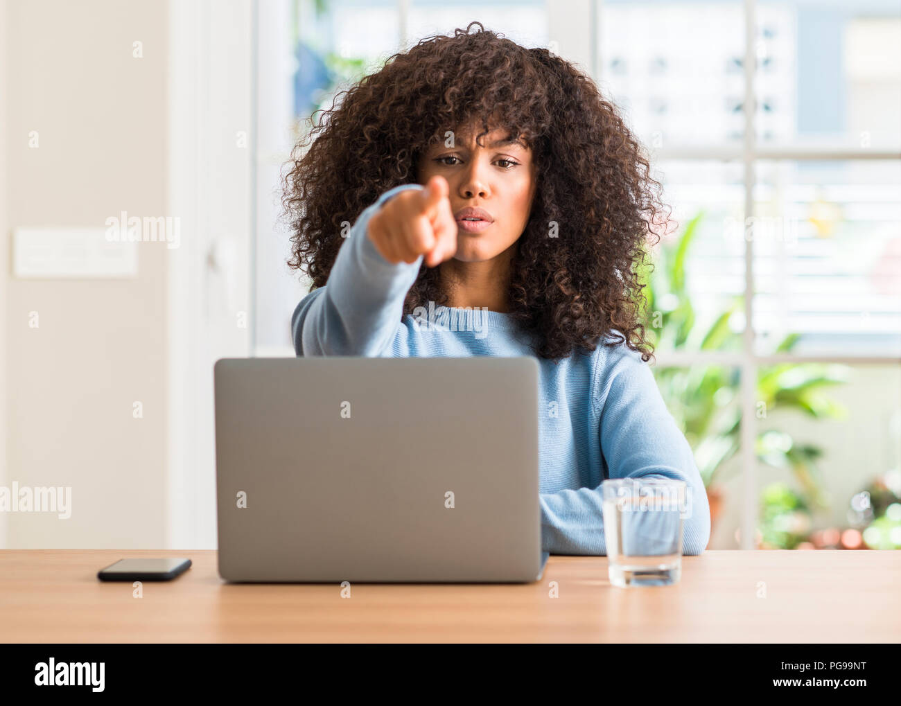 African american woman using laptop computer at home pointing with ...