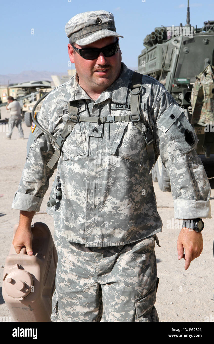 Sgt. Travis Hermann, a fire support noncommissioned officer with Headquarters and Headquarters Company, 1st Battalion, 112th Infantry Regiment, 56th Stryker Brigade Combat Team, 28th Infantry Division, carries supplies out of a Stryker in cantonment at the National Training Center, Fort Irwin, California, Aug. 18. Hermann lived in close quarters with his teammates in a Stryker for more than two weeks while being evaluated in multiple scenarios on the “battlefield” at NTC. (U.S. Army National Guard Photo by Sgt. 1st Class HollyAnn Nicom/released) Stock Photo