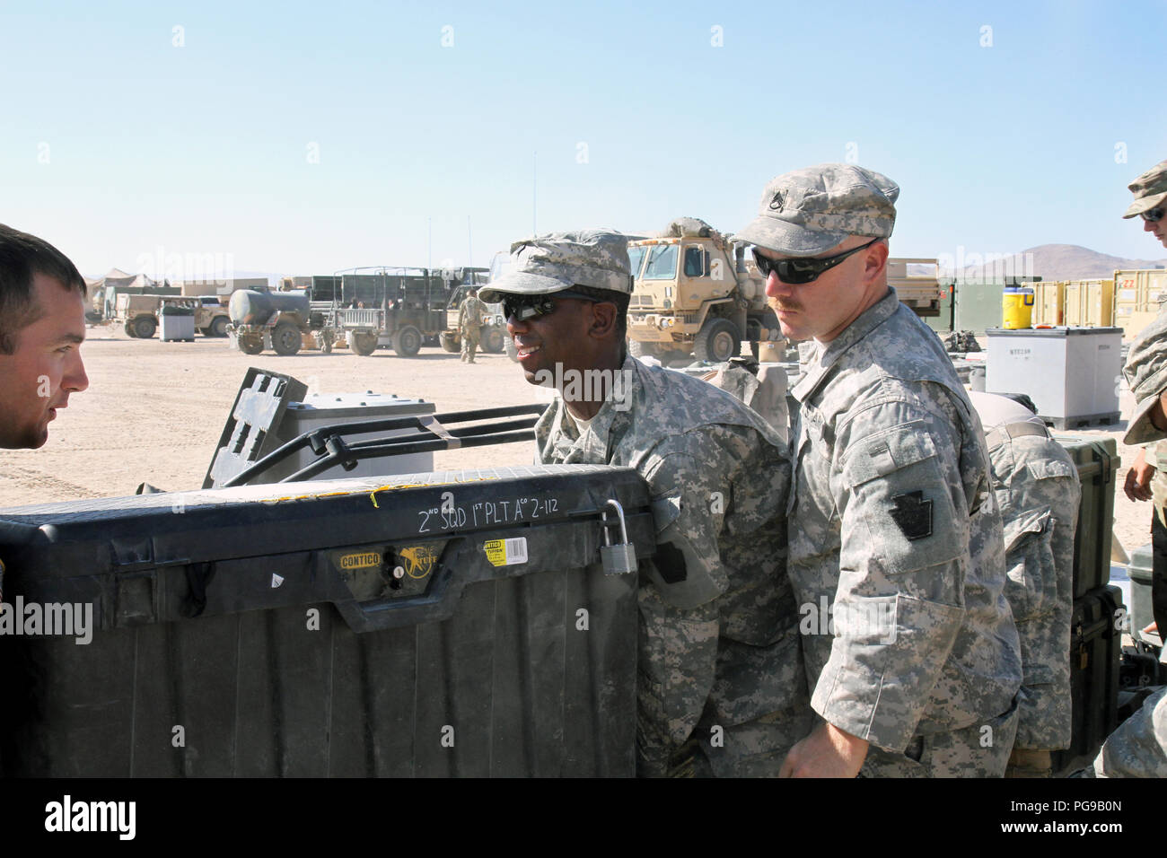 Spc. Chiquan Steele, Sr., a Harrisburg, Pennsylvania resident and indirect fire infantryman with Alpha Company, 2nd Battalion, 112th Infantry Regiment, 56th Stryker Brigade Combat Team, 28th Infantry Division, Pennsylvania Army National Guard, loads a squad box full of sensitive equipment into a connex in the motor pool at the National Training Center, Fort Irwin, California. He and others from his unit have spent the days following their return to cantonment of Fort Irwin unloading equipment from their vehicles and packing it for shipment back to their home station in Everett, Pennsylvania fo Stock Photo