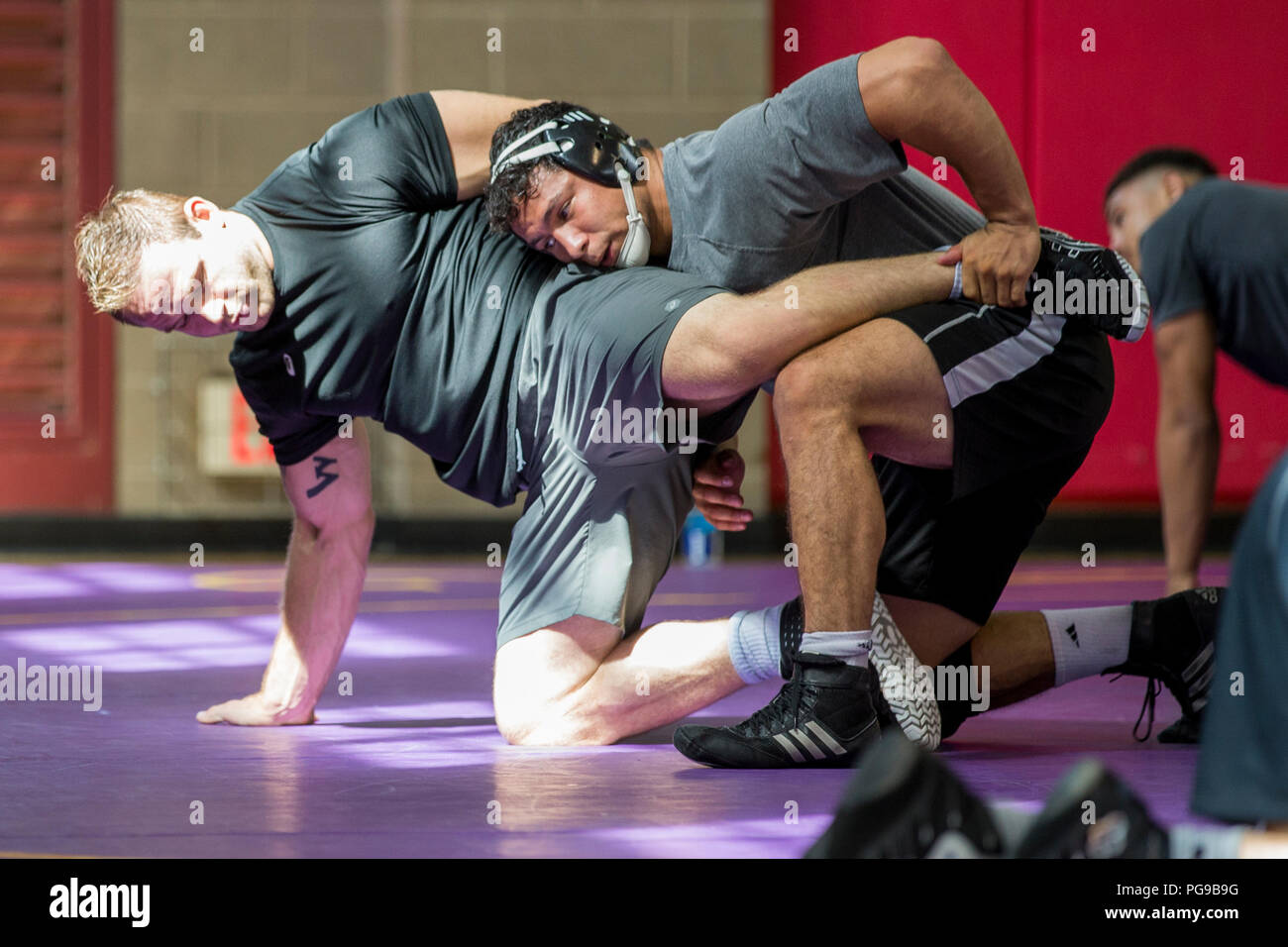 Ty Walz, left, wrestler, USA Wrestling Men’s Freestyle World Team, is being taken down by Michael Macchiavello, wrestler, USA Wrestling Men’s Freestyle World Team, at the 43 Fitness Center at Marine Corps Base Camp Pendleton, California, Aug. 20, 2018. Freestyle-wrestling, a style of amateur wrestling, is one of two types of wrestling featured in the Olympic Games. (U.S. Marine Corps photo by Lance Cpl. Betzabeth Y. Galvan) Stock Photo