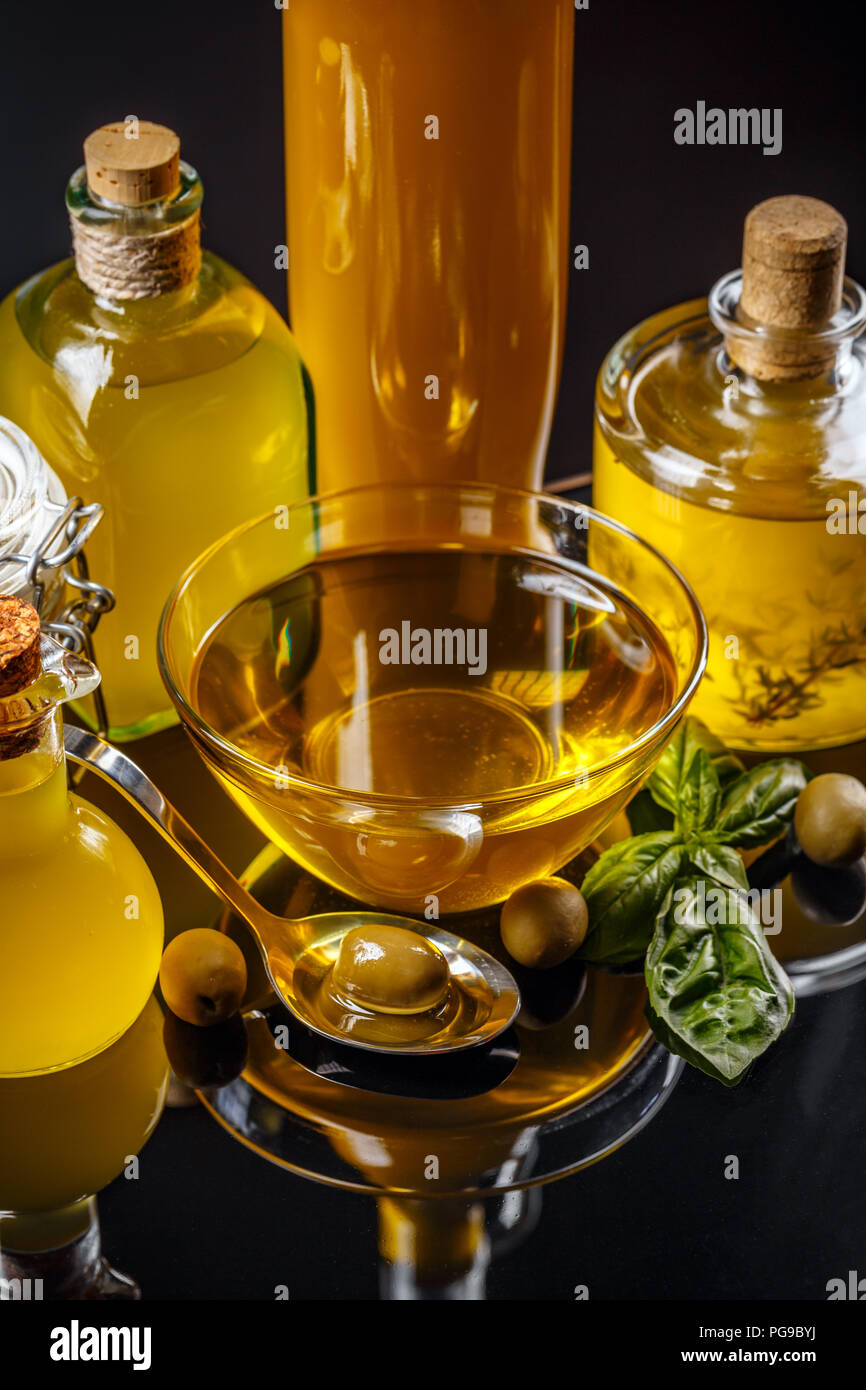 Pickled green olive in iron spoon and olive oil insmall bowl and