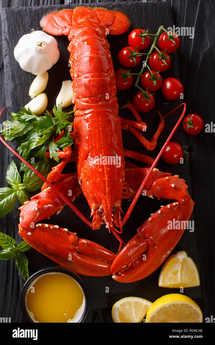 Shellfish plate of crustacean seafood with fresh boiled lobster with vegetables and herbs. gourmet dinner background. Vertical top view from above Stock Photo