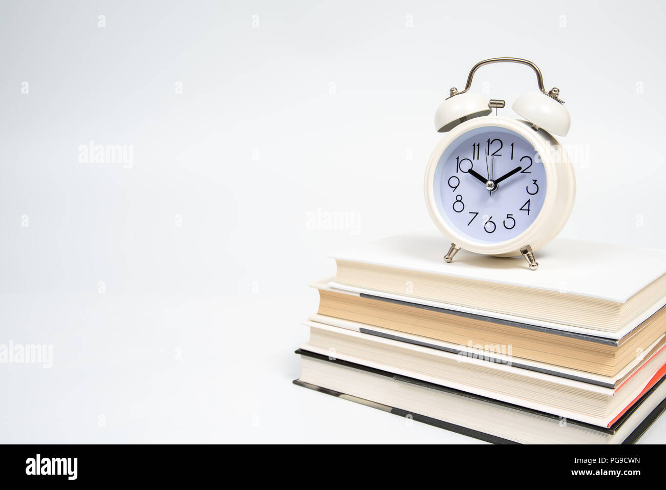 Alarm clock and books isolated on white background Stock Photo - Alamy