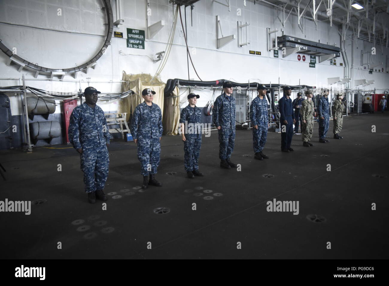 180820-N-MY760-068   PORTSMOUTH, Va. (Aug. 20, 2018) Sailors aboard the aircraft carrier USS Dwight D. Eisenhower (CVN 69)(Ike) stand at attention preparing to receive their Surface Warfare pins. Ike is undergoing a Planned Incremental Availability (PIA) at Norfolk Naval Shipyard during the maintenance phase of the Optimized Fleet Response Plan (OFRP). (U.S. Navy photo by Mass Communication Specialist Seaman Apprentice Tyler Miller) Stock Photo