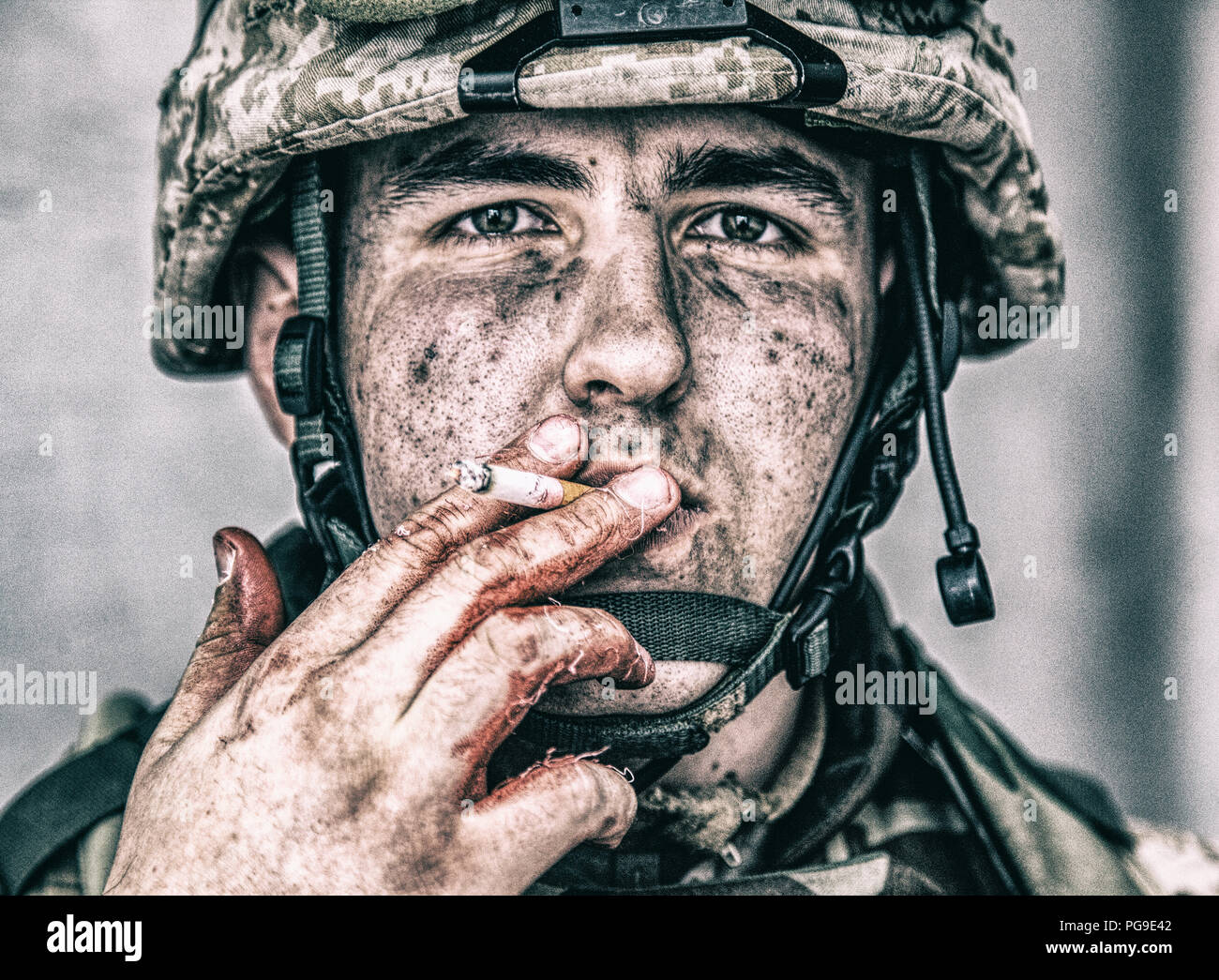 Stressed soldier with hands in blood smoking Stock Photo
