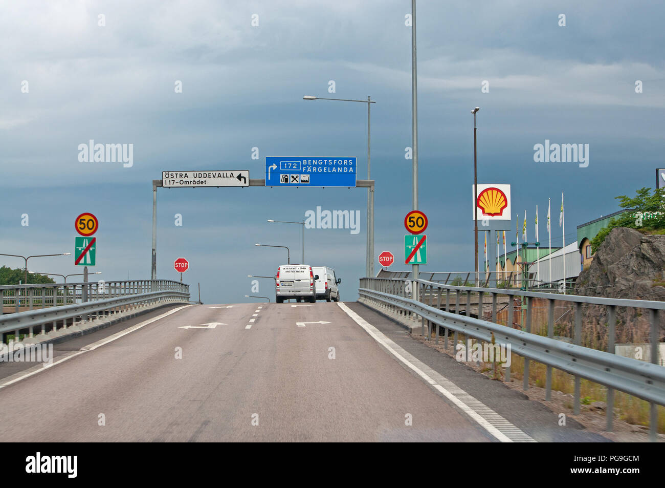 VANERSBORG, SWEDEN - JULY 1, 2012: Traffic crossing off motorway with  roadsigns and speed limit signs on a summer day on on July 1, 2012 in  Vanersborg Stock Photo - Alamy