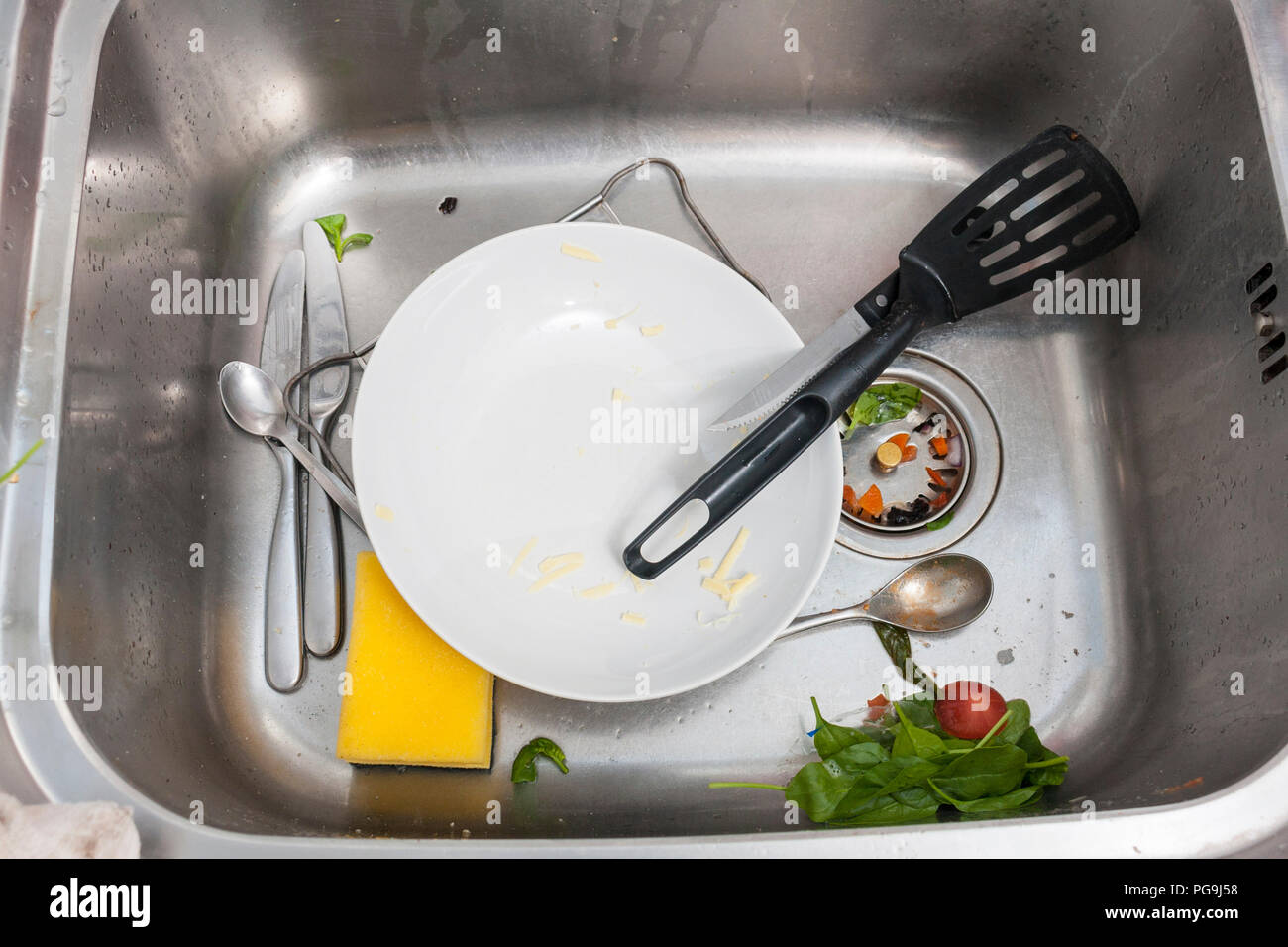 A stainless steel sink with dirty dishes and waste food Stock Photo Alamy