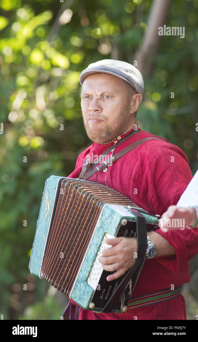 Legs of a young adult man sitting playing an accordion in a room Stock  Photo - Alamy