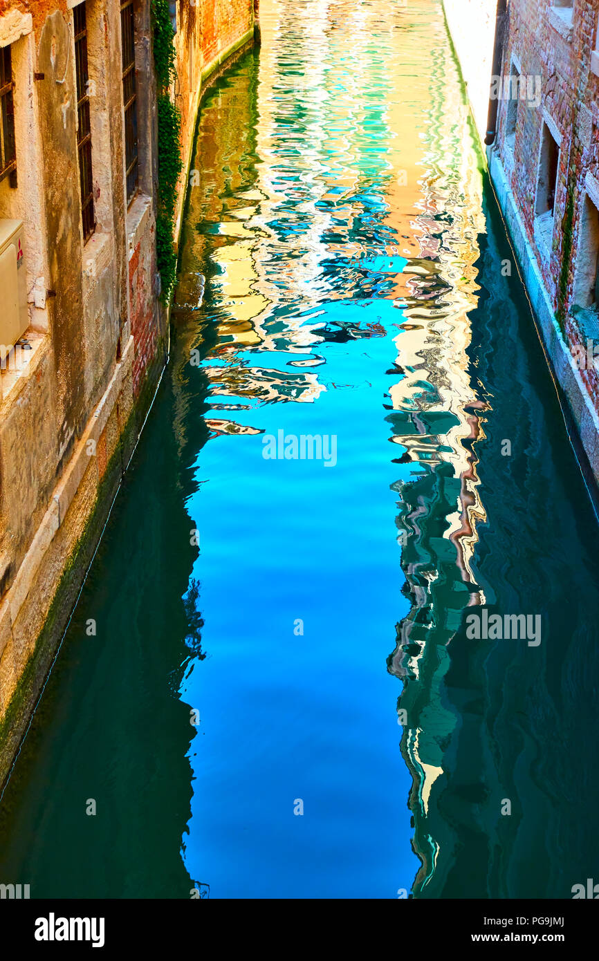 Venetian mirror - Houses and blue sky reflect in the water of canal Stock Photo