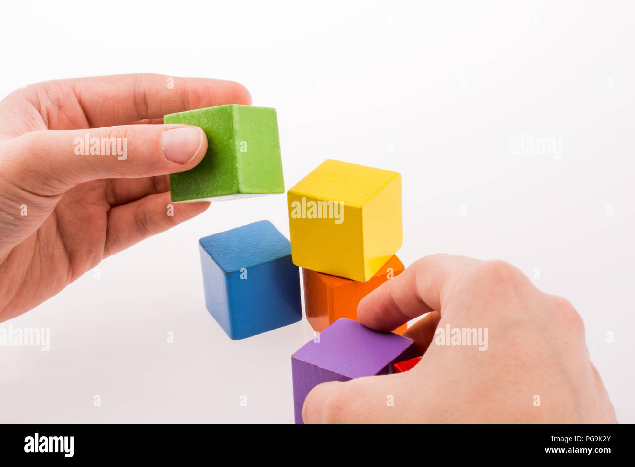 Hand playing with colorful cubes on a white background Stock Photo - Alamy