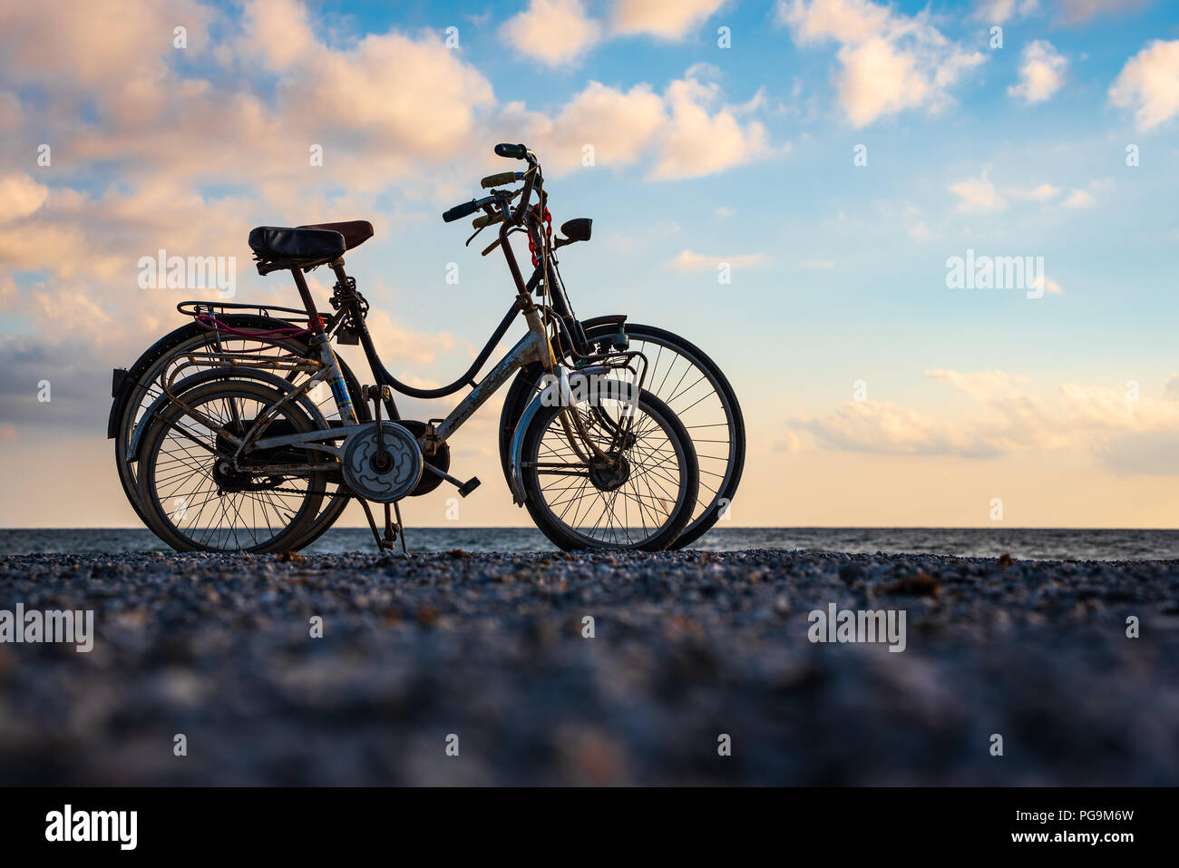 Bicycles in love during a sea sunset Stock Photo