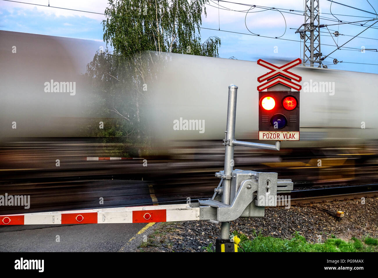 Ceske drahy, Czech railways, Cargo train passing a railroad crossing with red traffic lights flashing, Czech Republic Train, Europe Stock Photo