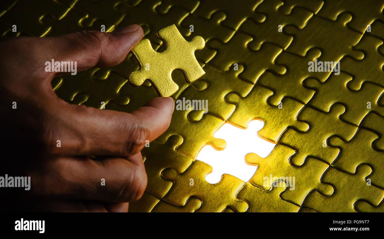 Final piece to the jigsaw puzzle success. Stock Photo