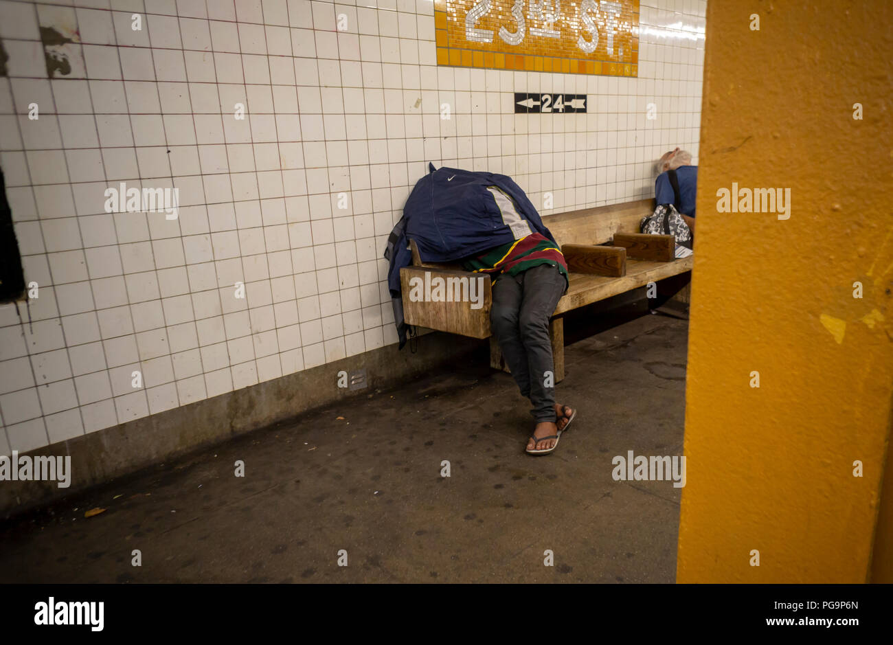 A homeless individual is seen sleeping in the West 23rd Street IND subway station in New York on Wednesday, August 22, 2018. (Â© Richard B. Levine) Stock Photo
