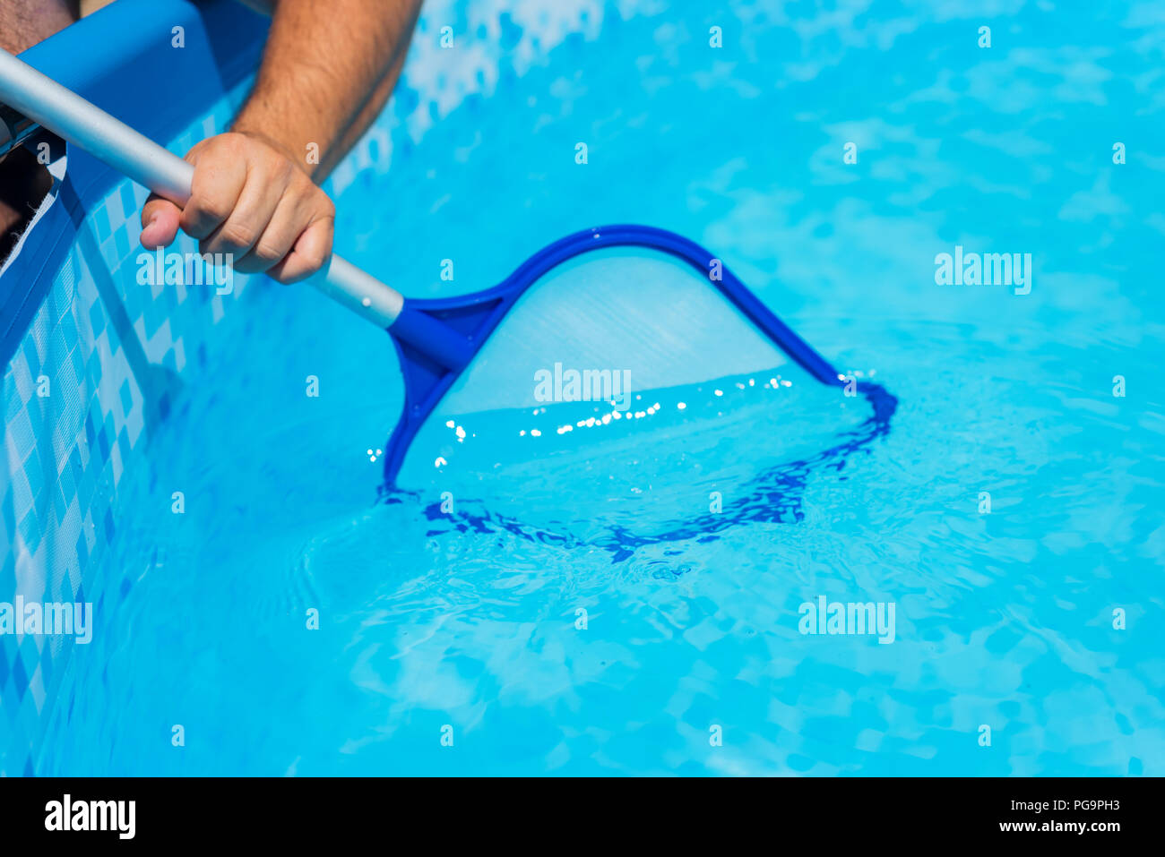 Backyard garden swimming pool cleaning close up Stock Photo