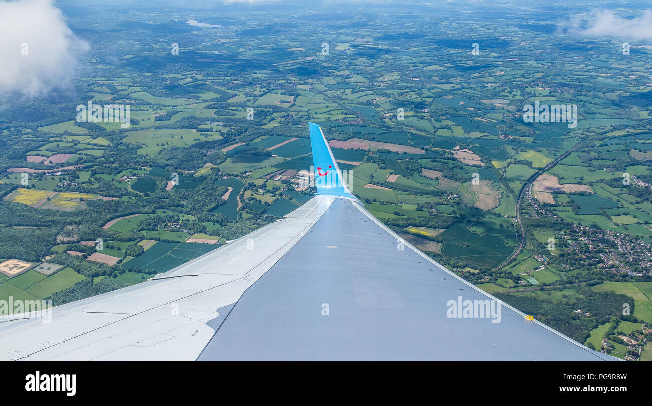 Fly from London Gatwick to Sicily in Italy by TUI Travel Air Shuttle.View from window on plane wing,below English countryside fields visible from air Stock Photo