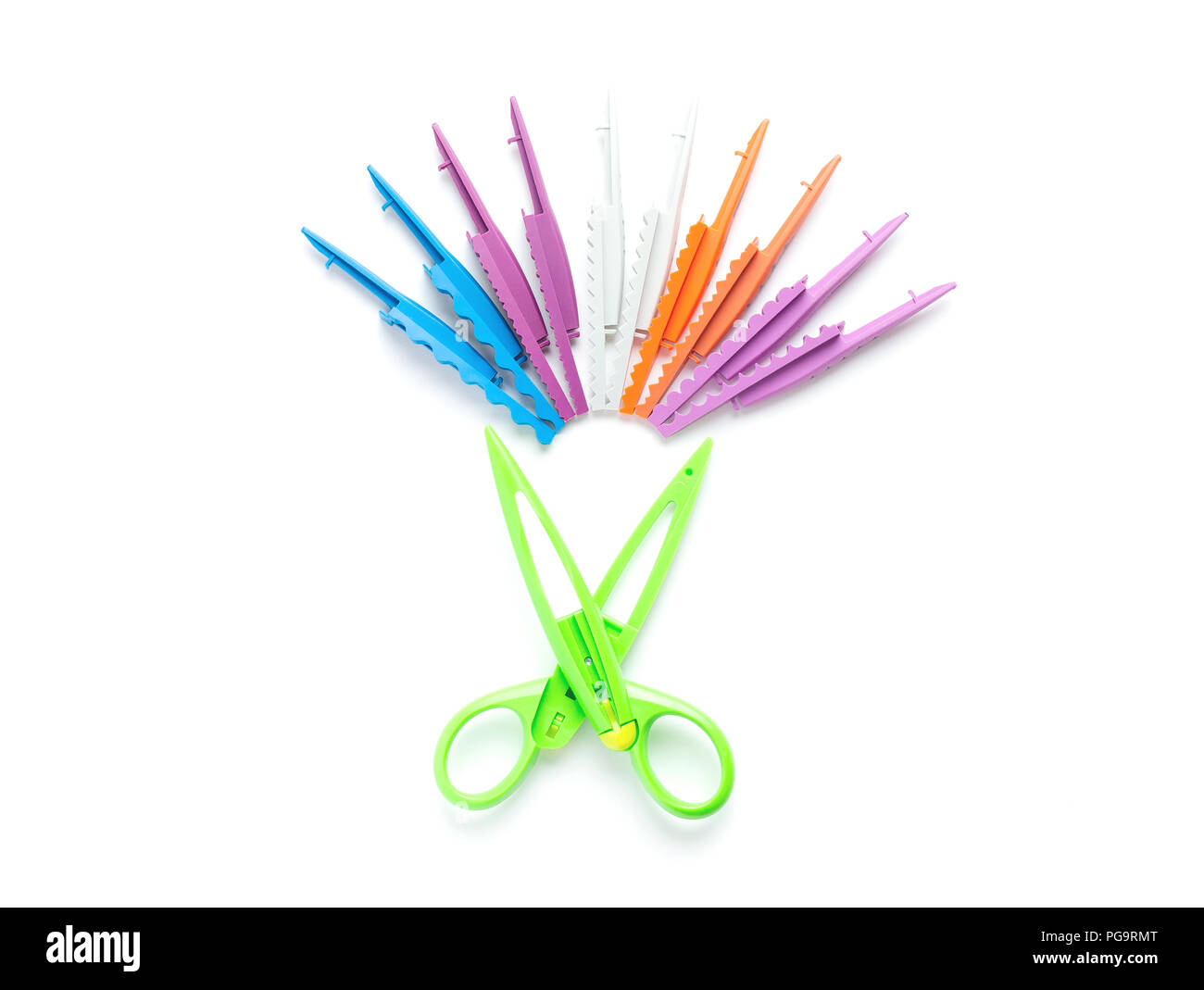 Green scissors with a wavy edge lie on a white background in the center