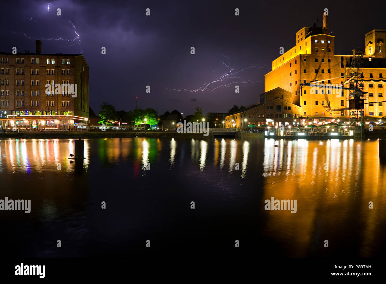 The modernized inner harbor area in Duisburg, Germany during a thunderstorm with reflection. Stock Photo