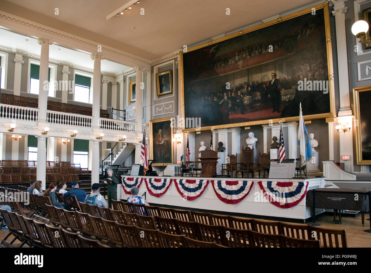 Tourists listen to a park ranger inside Faneuil Hall, sometimes called