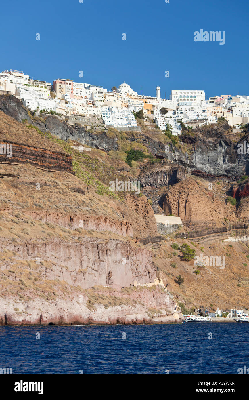 View from a boat to the crater wall of Santorini, Greece with the center of the capital Fira up on the crater rim. Stock Photo