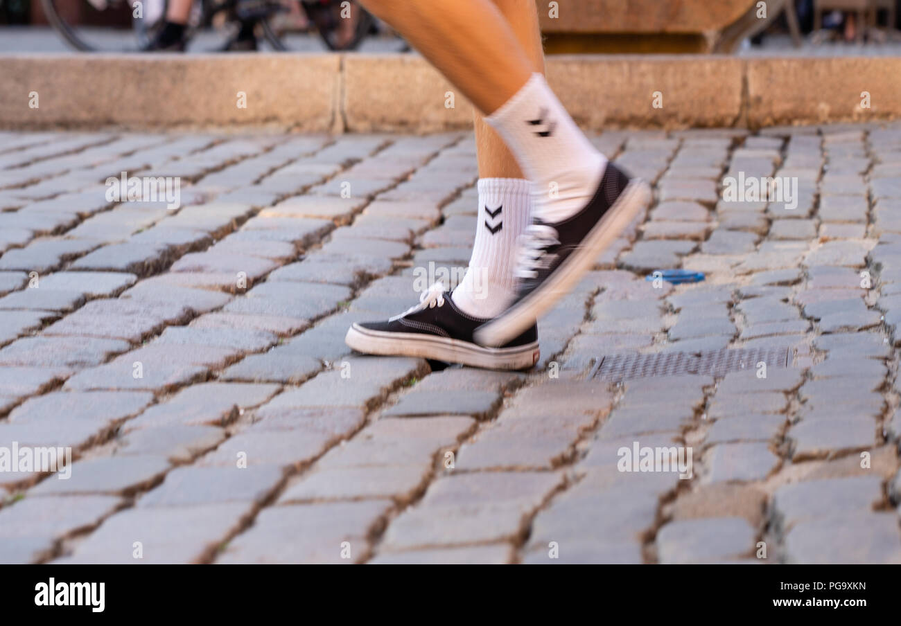 Feet in sneakers on Gråbrødretorv, Copenhagen Stock Photo