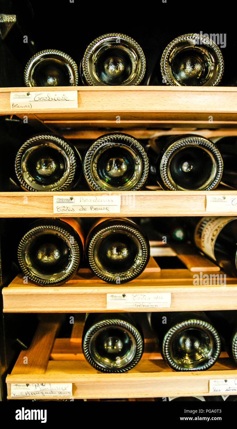 Champagne bottles stored horizontally in wooden racks inside a wine merchant store in Lille, France Stock Photo