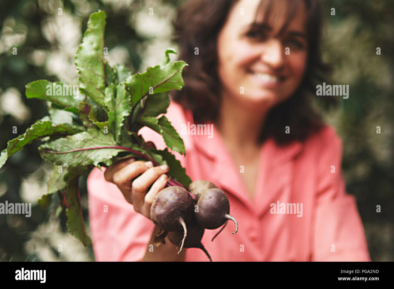 A market stall owner holding fresh organic beetroot. Organic vegetables