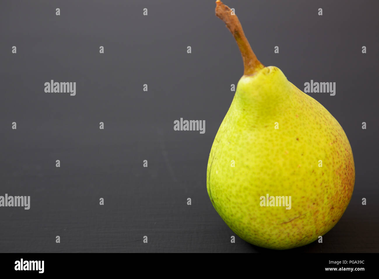 Pear Side View Tasty pear on a black background, side view. Close-up. Copy space Stock ...