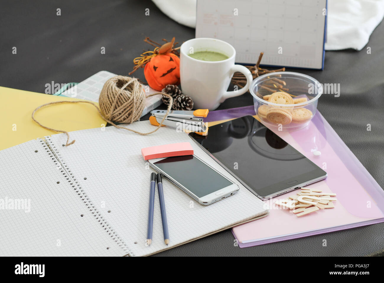Messy office desk depicting life at a busy office, chasing deadlines and the working millennial life Stock Photo