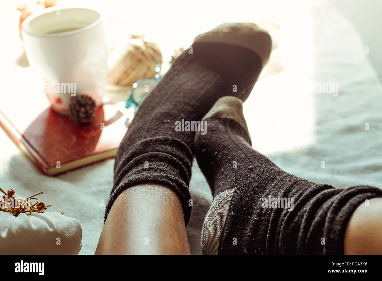 Warm socks and hot beverage to show the warmth and feelings of the autumn and winter season Stock Photo