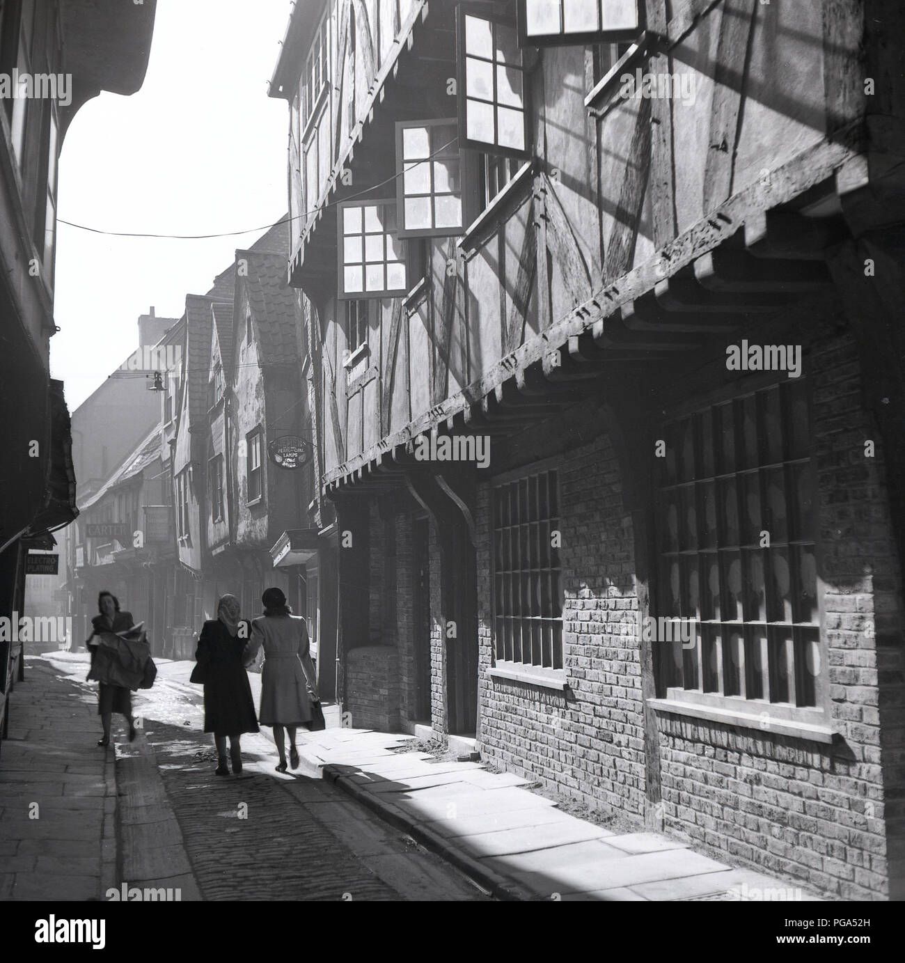 1950s, historical,  ladies walking through the shambles, York, England, UK, an ancient narrow  cobbled passageway, which in medieval times was a street of butchers. Stock Photo