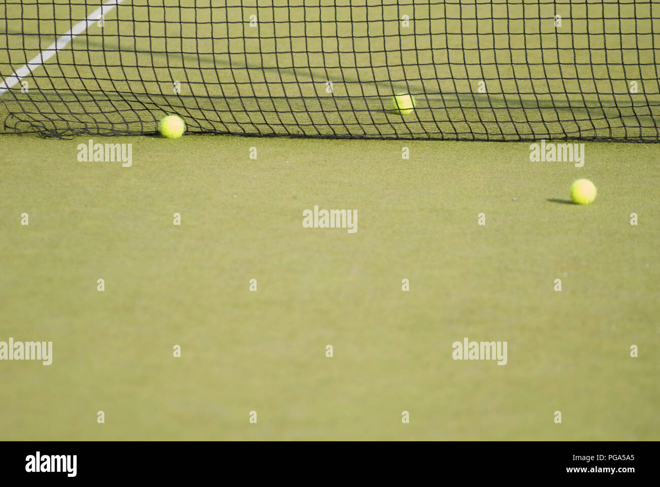 Three yellow tennis balls near the net. Error, failure, difficulty Stock Photo