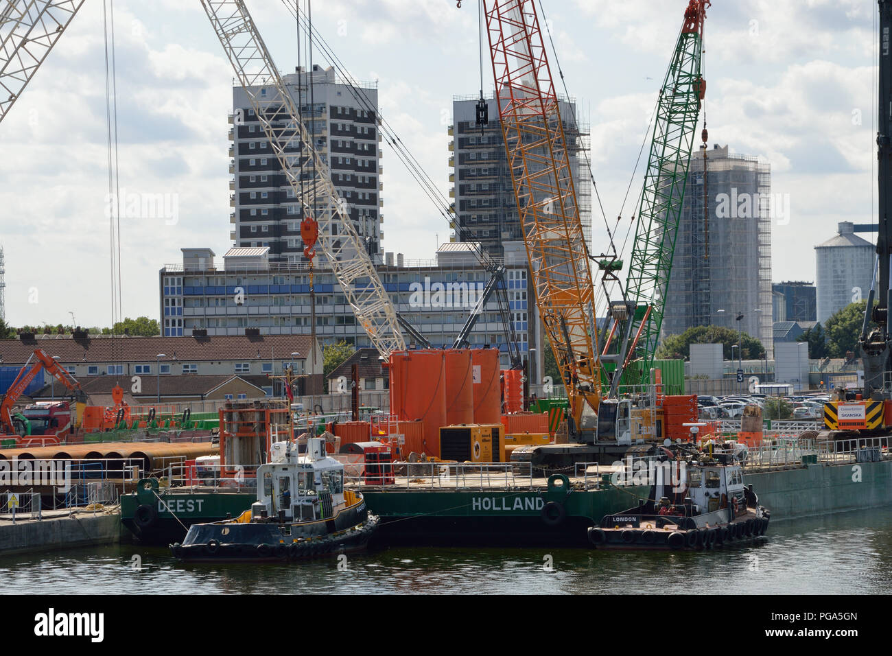 A barge with a crawler crane and a piling machine awaits it's next job in support of the London City Airport Development Project (CADP) works Stock Photo
