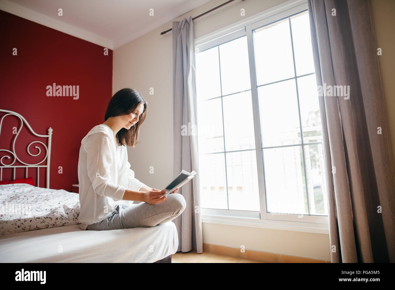 Woman reading book on bed in the morning. Vacation concept Stock Photo