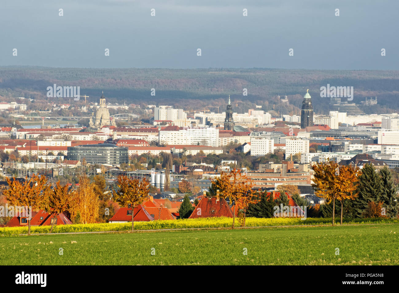 View in evening light over the city of Dresden from southwest with Frauenkirche, Town Hall Tower, Elbe and other sights, autumnal colored trees in for Stock Photo