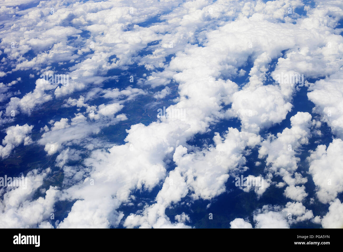 White fluffy clouds in blue sky, top view. View from airplane window ...